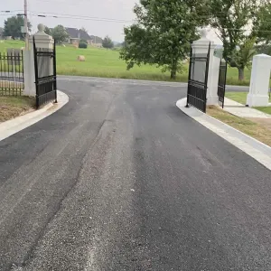 Rebuilt entrance drive and concrete curb between the cemetery's gate piers