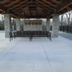 The completed committal shelter — timber roof structure, stone masonry and seating in place