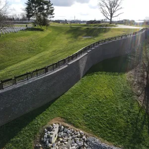 Finished MSE wall carrying the grade change between the burial sections and the lower ground