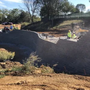 Block placement continuing along the wall with a loader feeding the crew